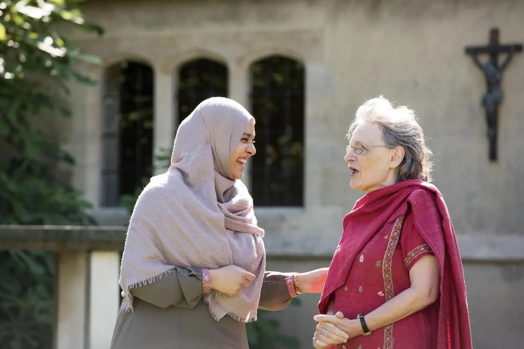 Two women from different backgrounds sharing a friendly conversation
