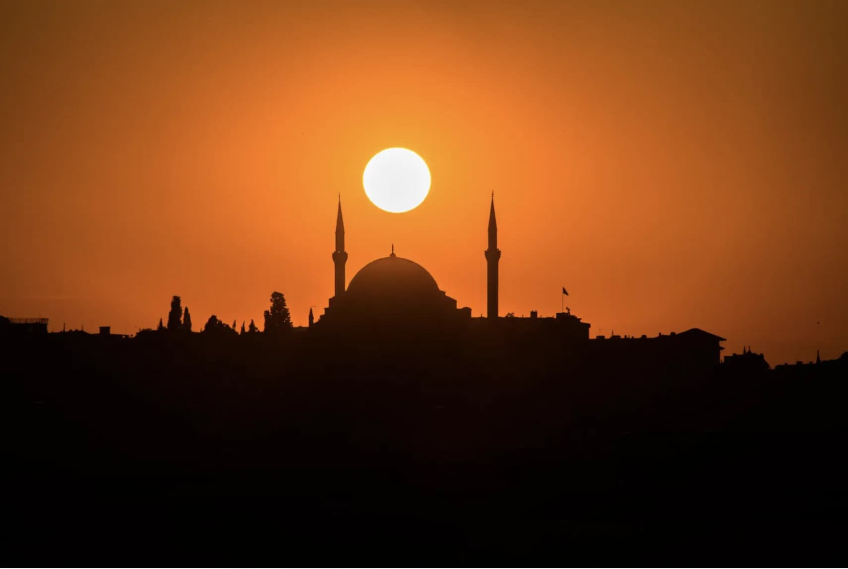 A mosque silhouetted against the warm evening sky