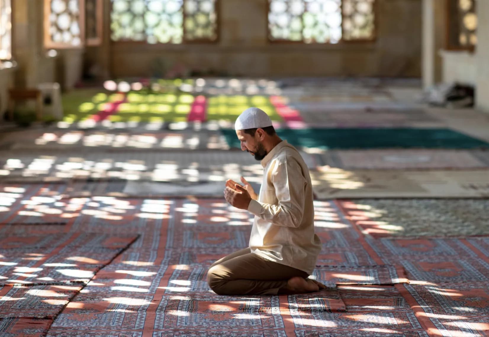 A Muslim praying in a naturally lit mosque